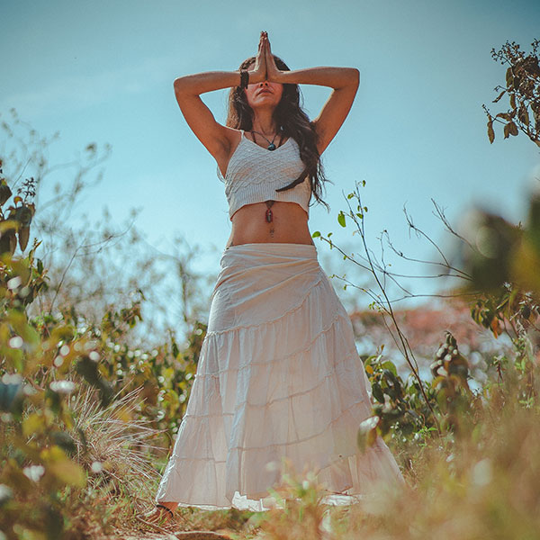 Young woman meditating in field in North Wales